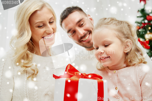 Image of happy family at home with christmas gift box