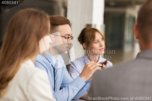 Image of businessman texting on smartphone at office
