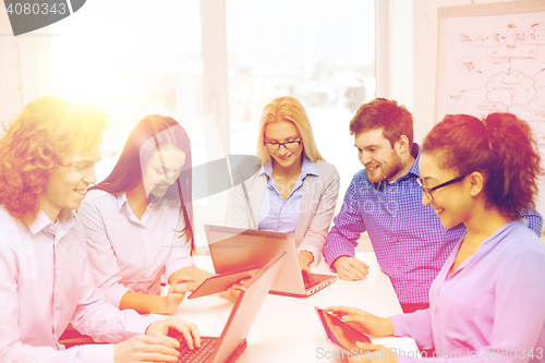 Image of smiling team with laptop and table pc computers