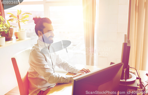 Image of happy creative male office worker with computer