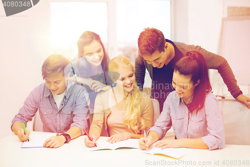 Image of smiling students with notebooks at school