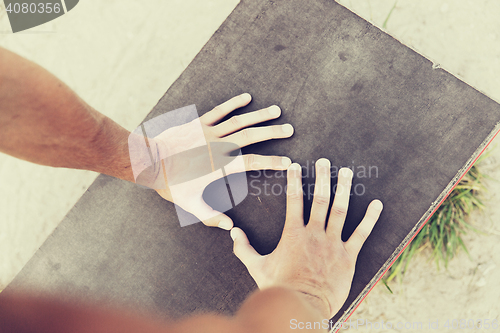 Image of close up of man hands exercising on bench outdoors