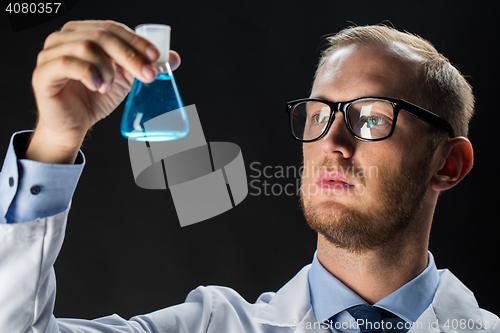 Image of young scientist holding test flask with chemical