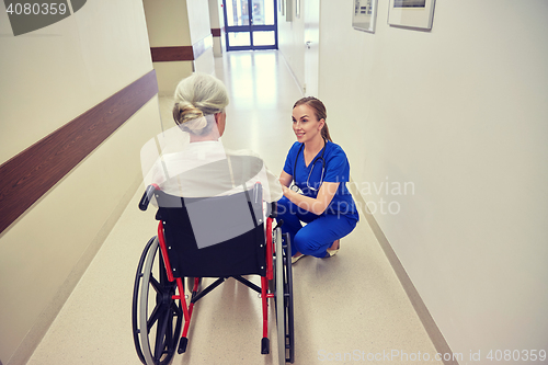 Image of nurse with senior woman in wheelchair at hospital