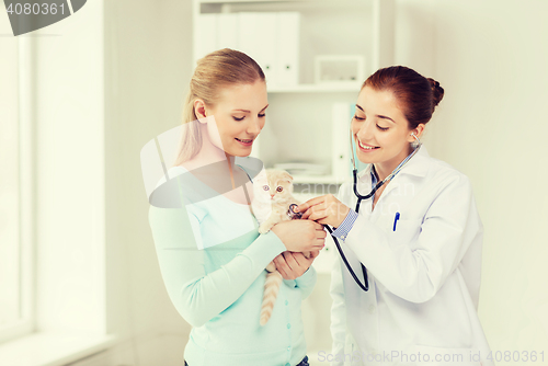 Image of happy woman with cat and doctor at vet clinic