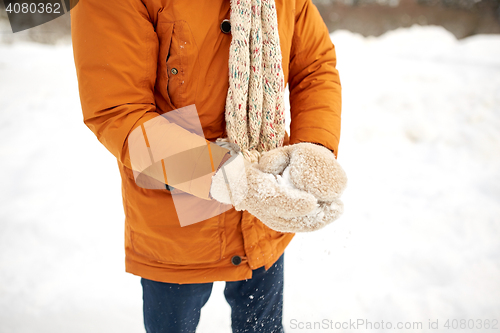 Image of close up of man with snowball in winter