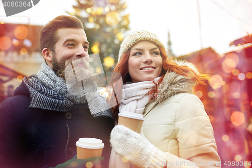 Image of happy couple drinking coffee on old town street