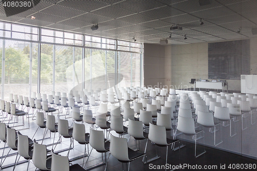 Image of Empty white chairs in contemporary conference hall with