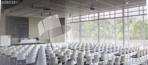 Image of Empty white chairs in contemporary conference hall with