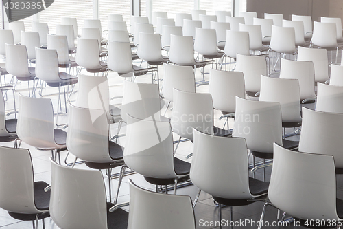 Image of Empty white chairs in contemporary conference hall with