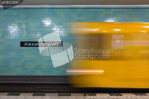 Image of Yellow subway train in motion on Berlin Alexanderplatz underground station.