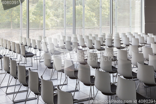 Image of Empty white chairs in contemporary conference hall with