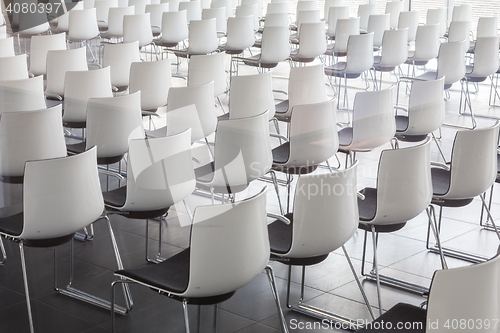 Image of Empty white chairs in contemporary conference hall with