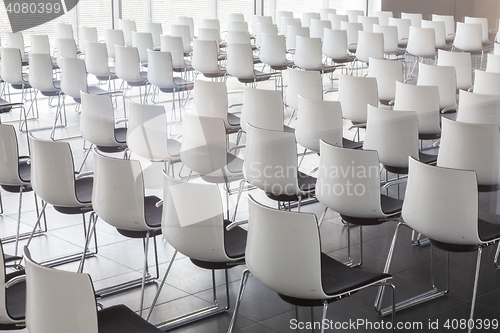 Image of Empty white chairs in contemporary conference hall with