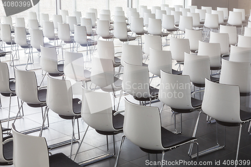 Image of Empty white chairs in contemporary conference hall with