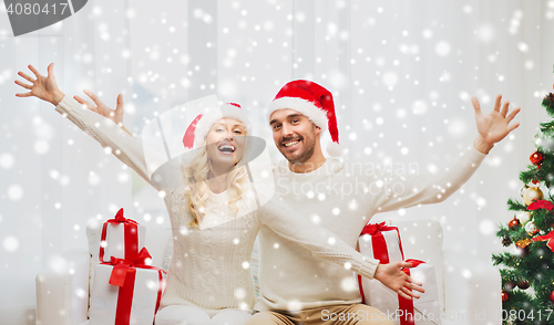 Image of happy couple at home with christmas gift boxes