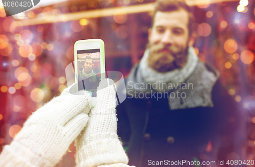 Image of couple taking picture with smartphone in old town