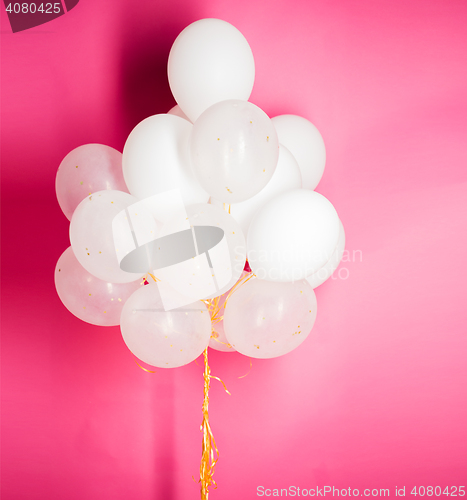 Image of close up of white helium balloons over pink