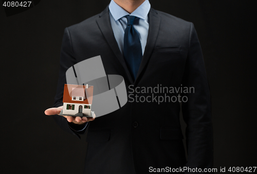 Image of close up of businessman holding house model