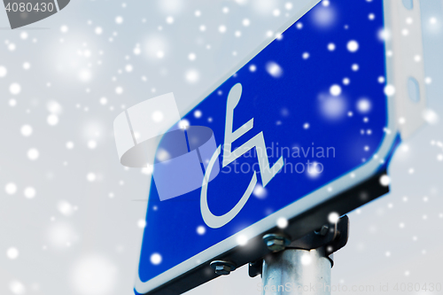 Image of close up of road sign for disabled over snow