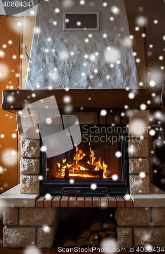 Image of close up of burning fireplace with snow