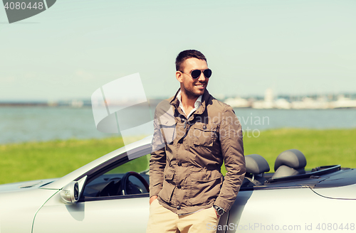 Image of happy man near cabriolet car outdoors