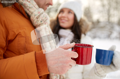 Image of close up of happy couple with tea cups in winter