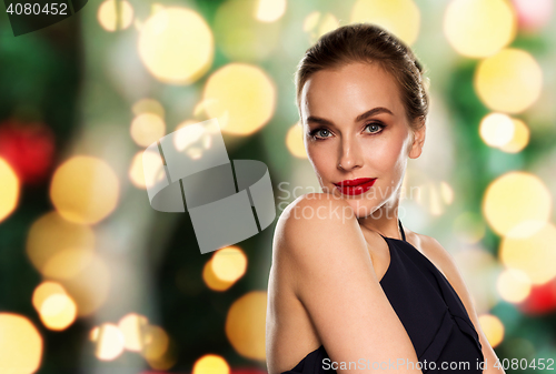 Image of beautiful woman in black over dark background