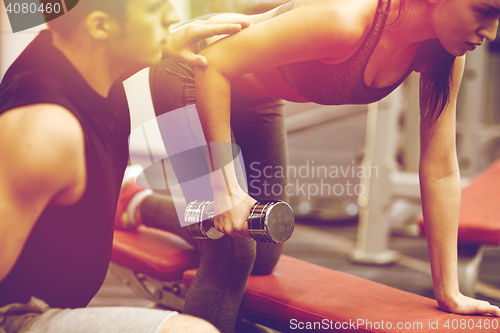 Image of close up of couple with dumbbell exercising in gym
