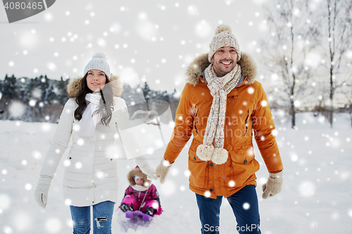 Image of happy family with sled walking in winter outdoors