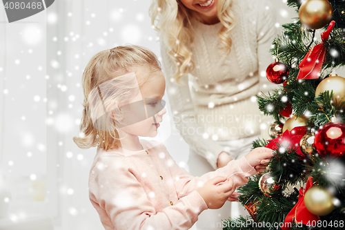 Image of happy family decorating christmas tree at home