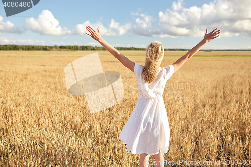 Image of happy young woman in white dress on cereal field