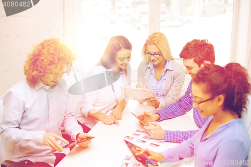 Image of smiling team with table pc and papers working