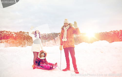 Image of happy family with sled walking in winter outdoors