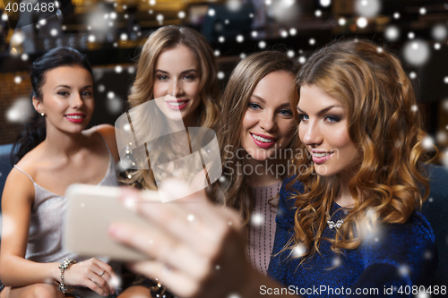 Image of women with smartphone taking selfie at night club