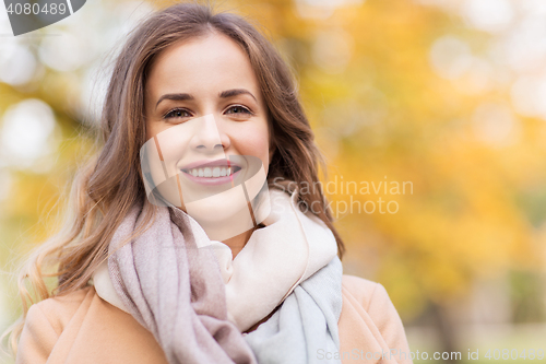 Image of beautiful happy young woman smiling in autumn park