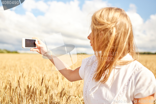 Image of close up of girl with smartphone on cereal field