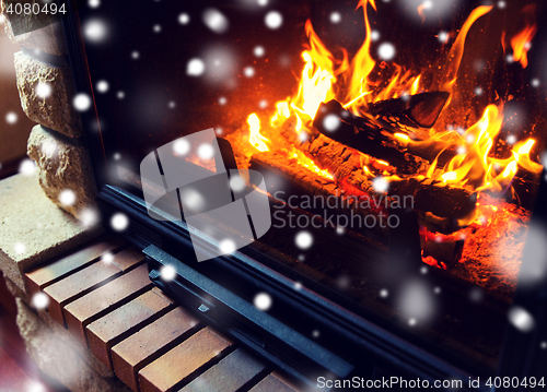 Image of close up of burning fireplace with snow