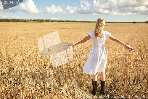 Image of happy young woman in white dress on cereal field