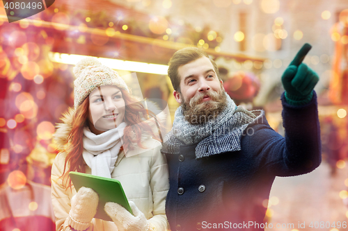 Image of happy couple walking with tablet pc in old town