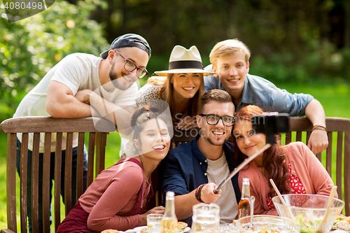 Image of friends taking selfie at party in summer garden