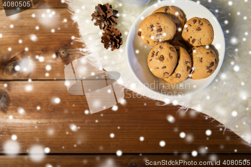 Image of close up of cookies in bowl and cones on fur rug