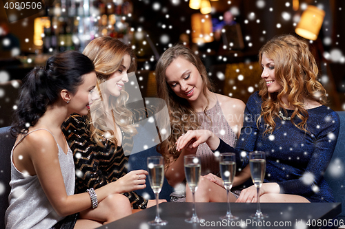 Image of woman showing engagement ring to her friends