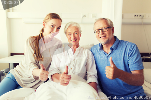 Image of happy family visiting senior woman at hospital