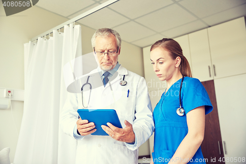 Image of senior doctor and nurse with tablet pc at hospital