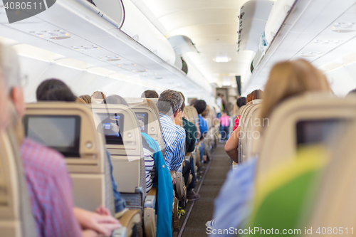 Image of Interior of airplane with passengers on seats waiting to taik off.