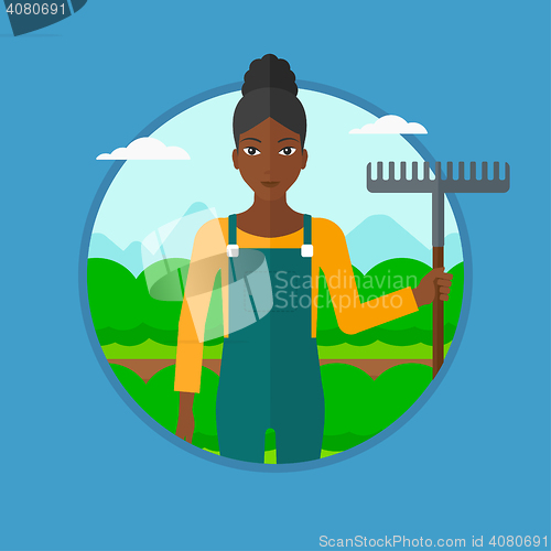 Image of Farmer with rake at cabbage field.