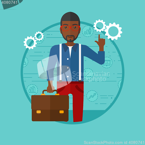 Image of Businessman pointing at cogwheels.