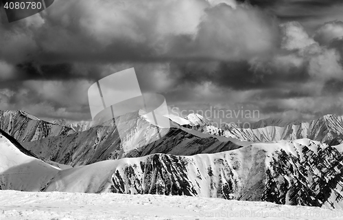 Image of Black and white winter snow mountains in storm clouds