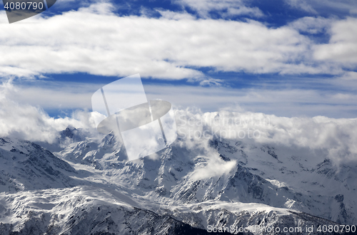 Image of Snow winter mountains in clouds at sun day